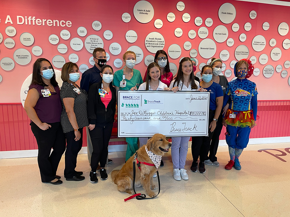 Hadley and Delany present a donation check to Joe DiMaggio Children's Hospital